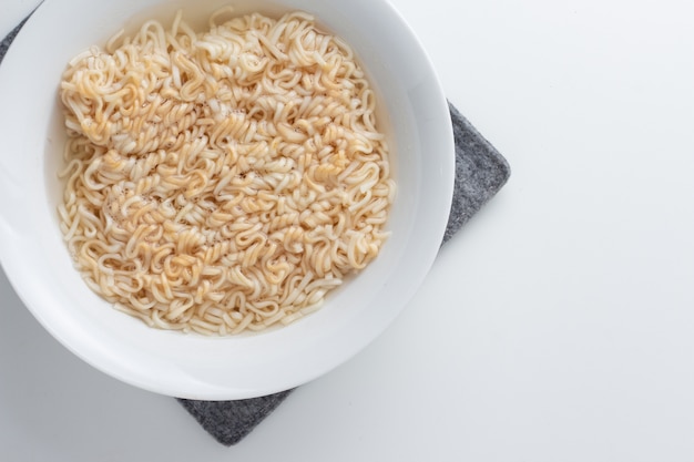 Noodle in bowl on white background top view