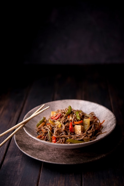 Noodles in bowl with chopsticks and copy space