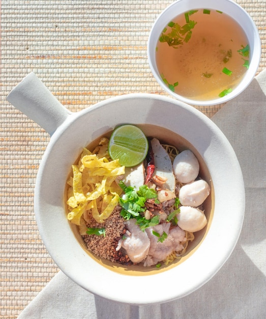 Noodles Tom Yum Thai food in a white bowl