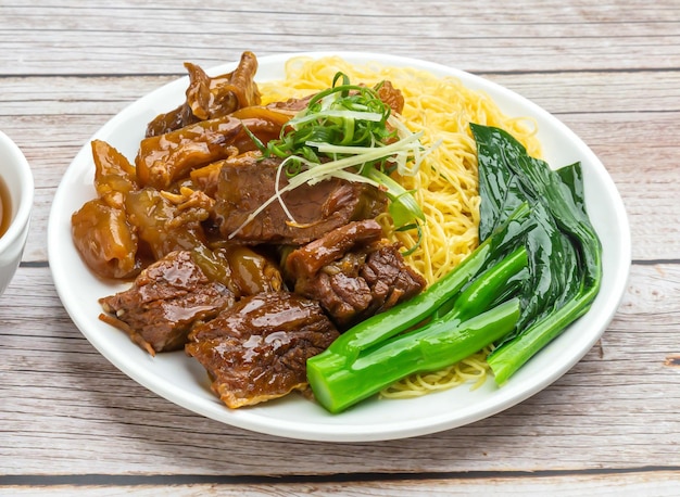 noodles with chuhau beef brisket served in dish isolated on wooden table top view hong kong food