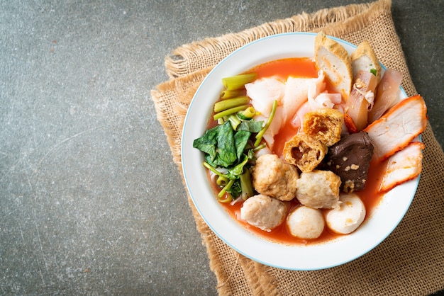 noodles with meatballs in pink soup or Yen Ta Four Noodles in Asian style