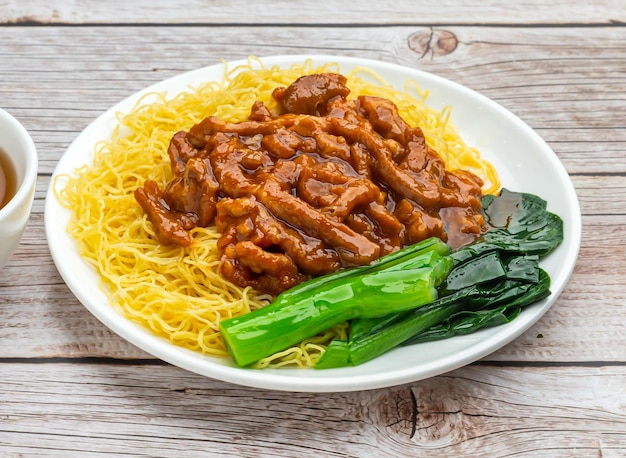 noodles with soy bean paste served in dish isolated on wooden table top view hong kong food