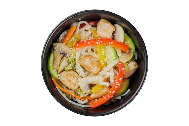 Noodles wok with vegetables herbs and sesame In a black round plate On a white background