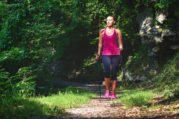 Nordic walking. A young woman on a hike in the woods