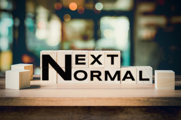 Next Normal word on wooden cube block on wood table background