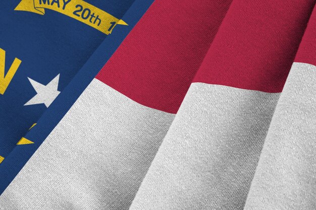 North Carolina US state flag with big folds waving close up under the studio light indoors The official symbols and colors in banner