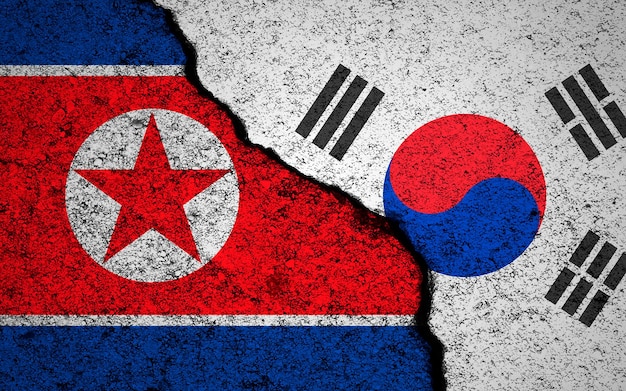 North Korea and South Korea flags background Cracked wall Military conflict and war concept photo