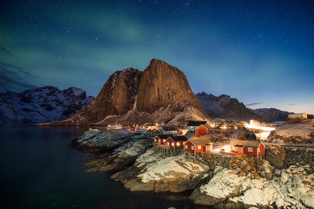 Northern lights over mountain in fishing village at Hamnoy