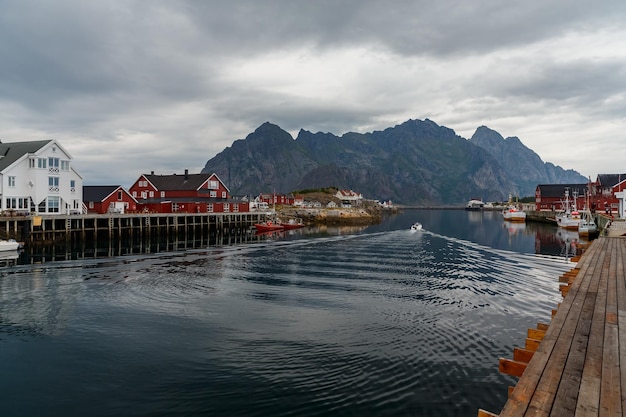 Norwegian seascape cityscape of the town henningsvaer a small boat moves between peninsulas sail