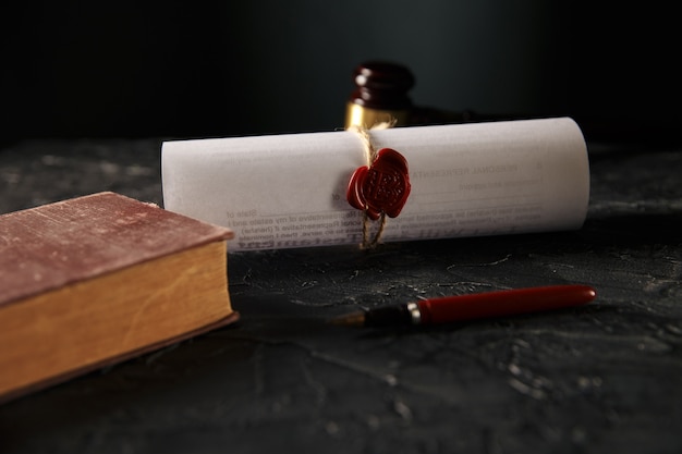 Photo notary and law concept. stamp with book and pen on the table. wooden gavel behind.