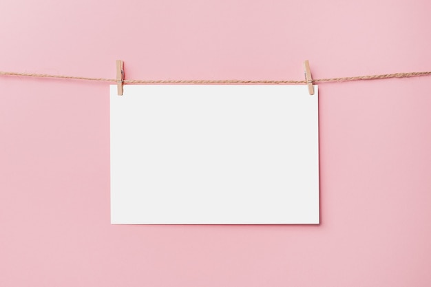 Note letter pin on rope on pink background, love and valentine concept