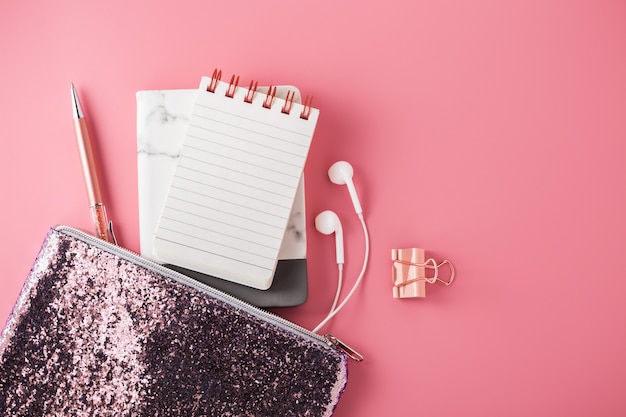 Note pad with pen in fashion bag on pink background