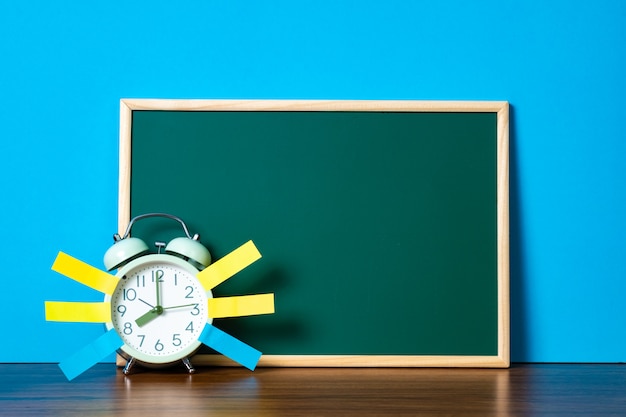 Note paper sticky and vintage alarm clock and blank green chalkboard