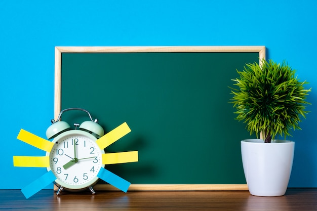 Note paper sticky and vintage alarm clock and blank green chalkboard