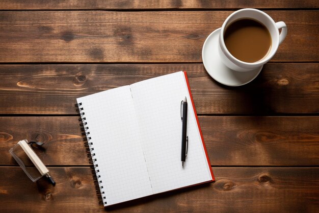 A notebook and a cup of coffee on a wooden table