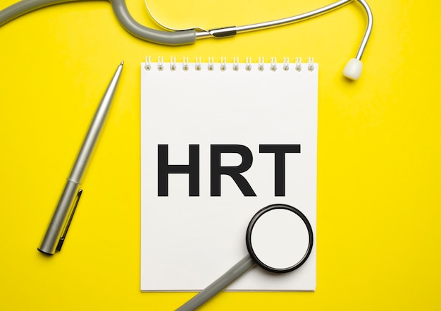 In the notebook is the text hrt and stethoscope on yellow background