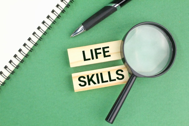 notebook, magnifying glass, pen with the words Life Skills. the concept of skills in life