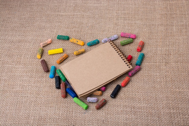 Notebook in the middle of crayons form a heart