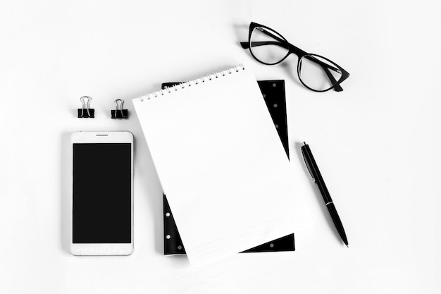 Notebook, pen, eye glasses, mobile phone and white sheet of paper