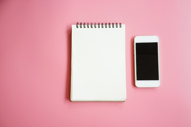 notebook and smartphone on pink background