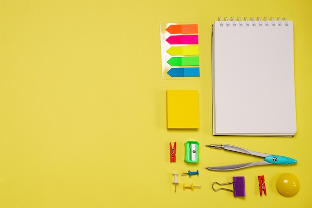 Notebook on a spring for notes and stationery lie on a yellow background