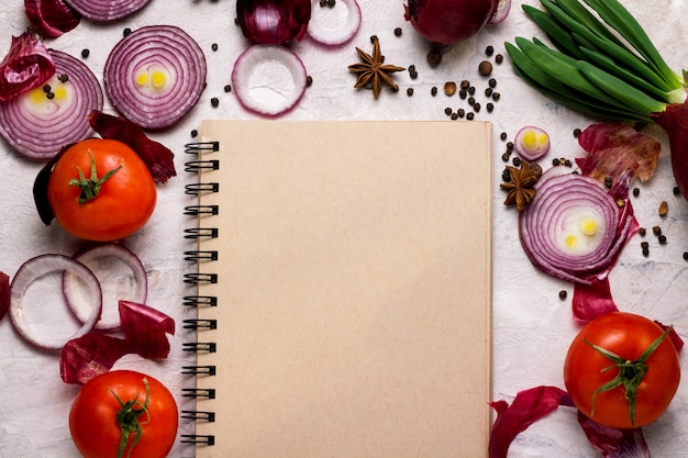 Notebook and vegetables on a light background.