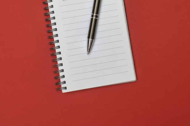 A notebook with a blank page and a pen resting on it