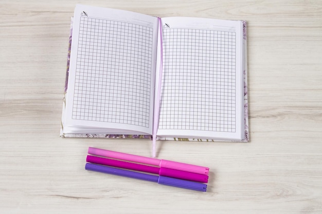 Notebook with colorful marker on wooden table