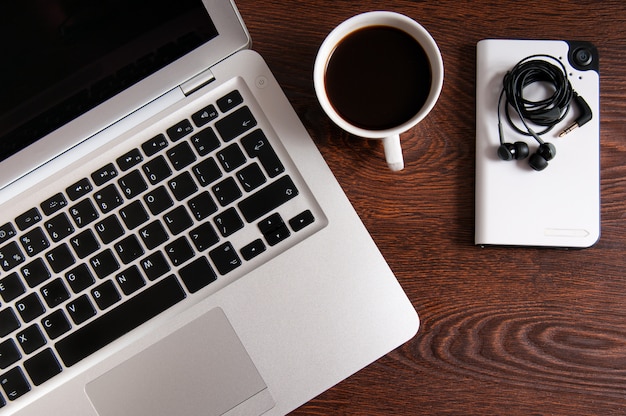 Notebook with hot coffee on wood table