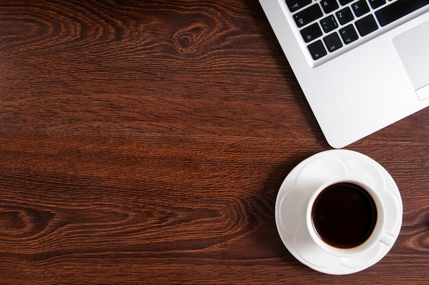 Notebook with hot coffee on wood table