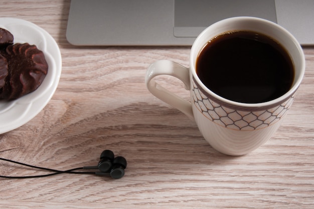 Notebook with hot coffee on wood table