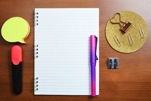 Notebook With Important Message On Desk With Pen Sharpener Notes Paperclips And Marker Notepad With Crutial Information On Table With Office Supplies