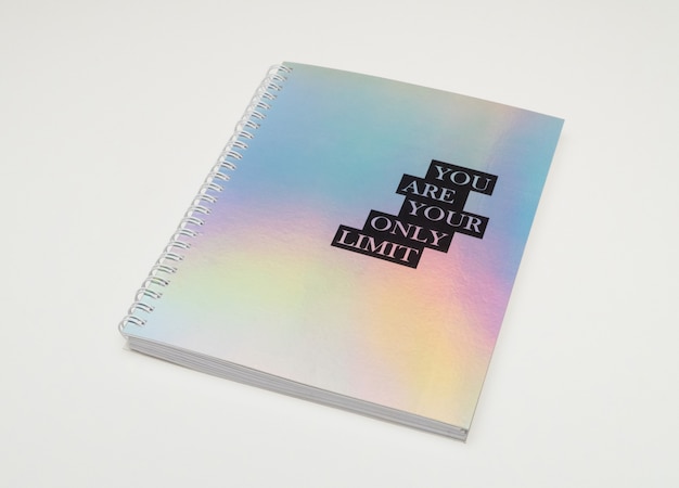 A notebook with iridiscent cover and motivational text, white background