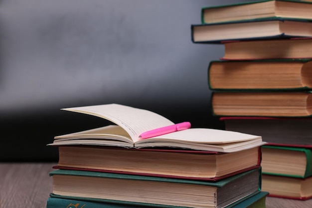 Notebook with pen on a background of books, selective focus