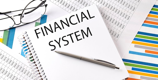 Notebook with text FINANCIAL SYSTEM Diagram and white backgroundBusiness concept