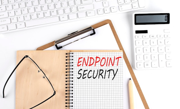 Notebook with the word ENDPOINT SECURITY with keyboard and calculator on the white background