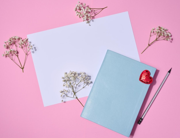 Notebook wooden pencil on pink background top view