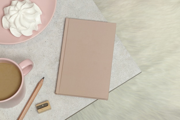 Notebook, wooden pencil and sharpener, cup of coffee, marshmallow on granite table 