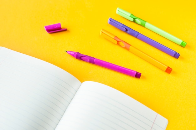 Notebooks in a box and in a line near to handles on a yellow background