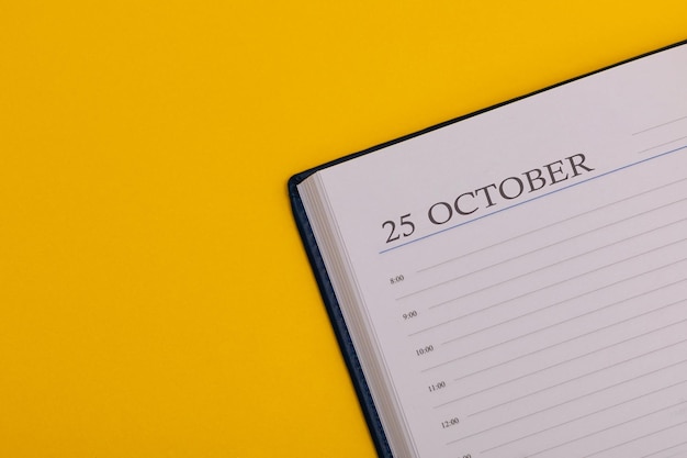 Notepad or diary with the exact date on a yellow background Calendar for October 25 fall time Space for text