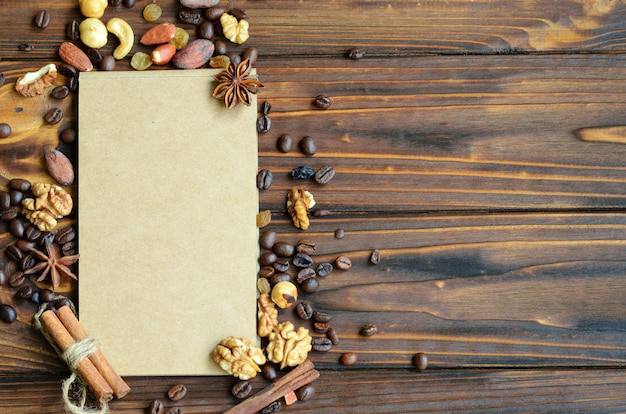 Notepad with craft paper pages surrounded by a frame of coffee beans, raisins, nuts