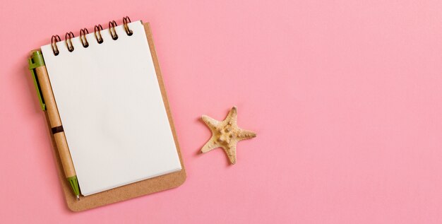 Notepad with starfish on pink background