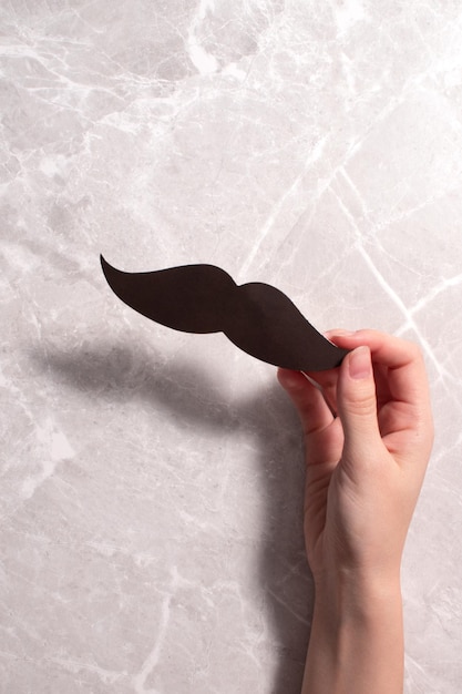 November is month of men health issues and prostate cancer awareness Woman holding paper moustache Happy Fathers day