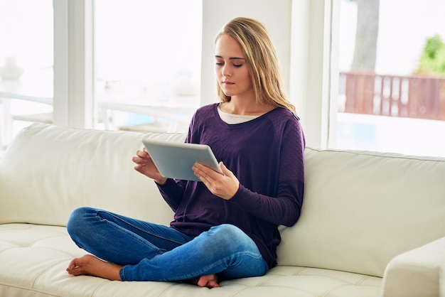 Now she can blog from anywhere Full length shot of an attractive young woman using her tablet while chilling at home