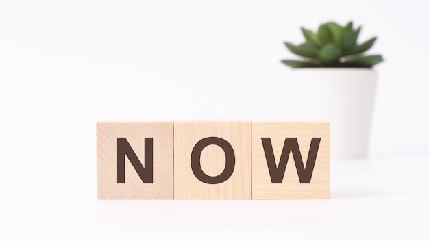 NOW text on wooden cubes white background business concept