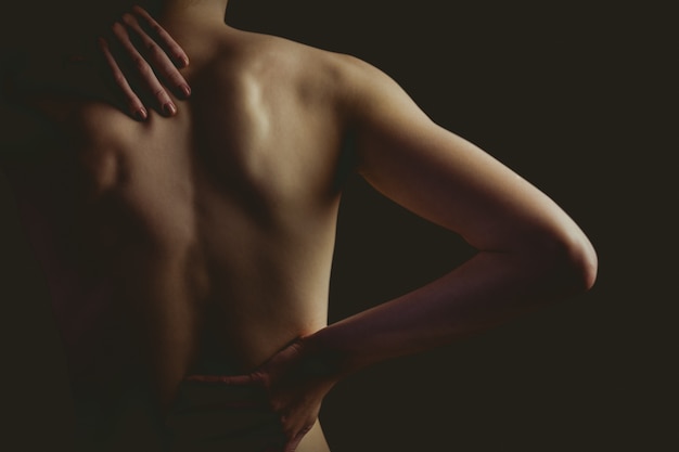 Nude woman with a back injury