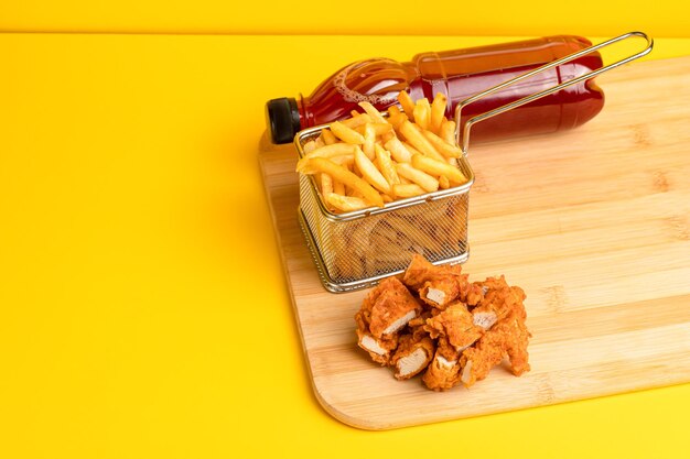 Nuggets with potatoes and fruit juice yellow background side view