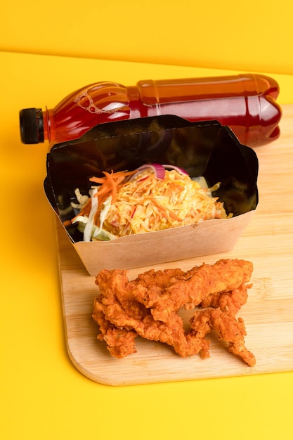 Nuggets with salad and fruit juice yellow background side view