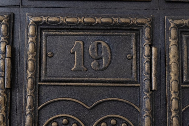 Number 19 on metal door Old vintage retro copper plate with the number nineteen Antique mailboxes