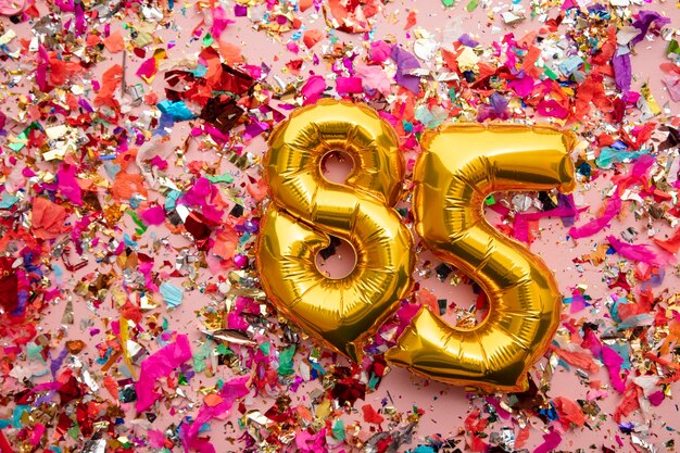 Number  gold birthday celebration balloon on a confetti glitter background